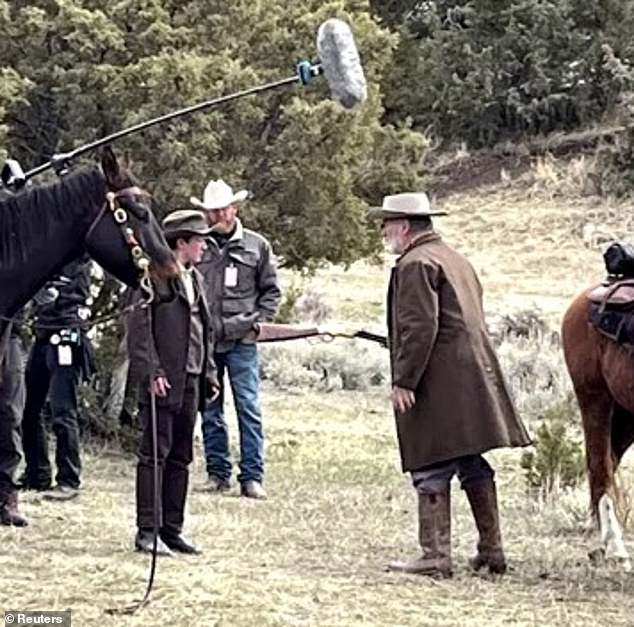 Alec Baldwin holds a shotgun the WRONG way around as filming continues on set of Rust