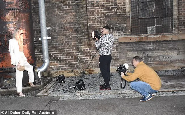 Jono Castano holds up a light on girlfriend Simone Holtznagel as she does a shoot at Fashion Week