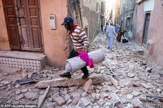 A man carries his belongings through the rubble in the old city area of Marrakesh on Saturday morning