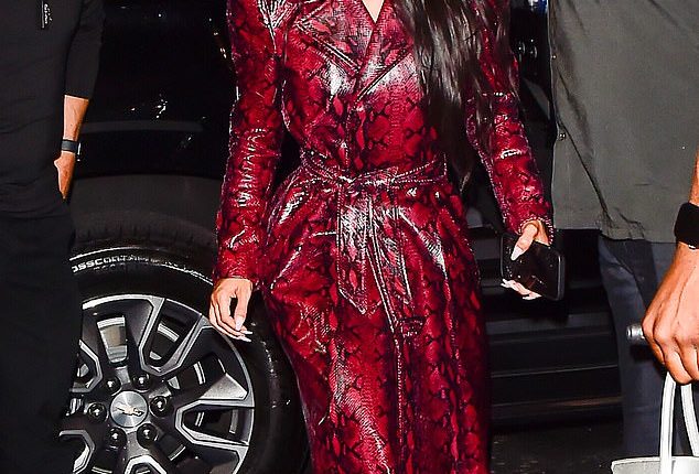 Stylish: The SKIMS founder showed off her incredible style while looking red hot in a vivid snakeskin trench coat