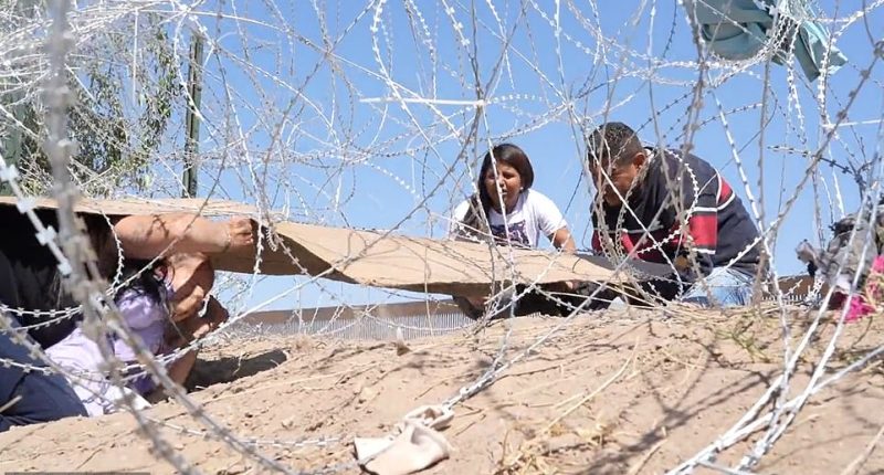 Shocking footage shows a mother and her young child crying out in horror as they crawl under a razor fence at the US southern border - only to be turned back the same way by Border Patrol agents. The video, taken in Juarez on the Mexico side of the border sees the group of Venezuelans placing cardboard on their backs to avoid being cut while crawling under the barb-wire obstacle placed to stop travelers from entering El Paso.