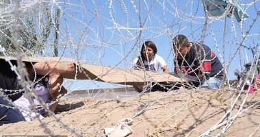 Shocking footage shows a mother and her young child crying out in horror as they crawl under a razor fence at the US southern border - only to be turned back the same way by Border Patrol agents.