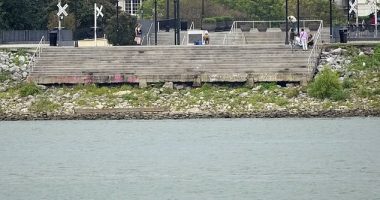 The low water level of the Mississippi River is seen as people sit on steps that normally meet the river in the French Quarter of New Orleans, on  September 25, 2023