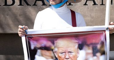 A fan of Donald Trump is seen on Wednesday outside the Reagan National Library - despite Trump being 2,000 miles away