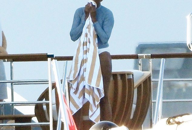 Michelle Obama dries off after a dip in the Med with her Hollywood pals Tom Hanks and Steven Speilberg