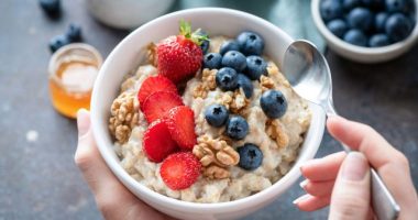 bowl of oatmeal with strawberries and blueberries and walnuts