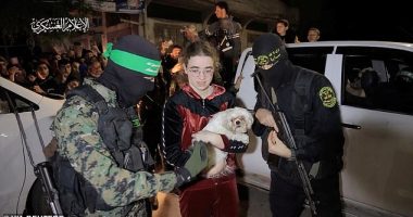 A teenage hostage clutches her dog, a Shih Tzu called Bella, as she is flanked by Hamas gunmen during her release