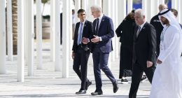Rishi Sunak insists Britain is a 'leader' and can 'walk tall' at Cop28 climate summit in Dubai... as he is relegated to the back row of 'family photo' behind Albania