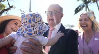 Prime Minister Anthony Albanese with Labor candidate for Bonner, Kara Cook, and a baby during a visit to a an early voting polling place, in the electorate of Bonner, in Wynnum