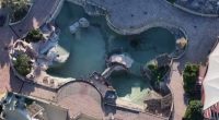 Aerial view of an abandoned marine park with two orcas and twelve dolphins.