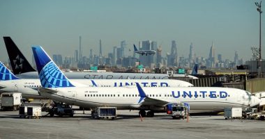 United Airlines planes at an airport with a city skyline in the background.