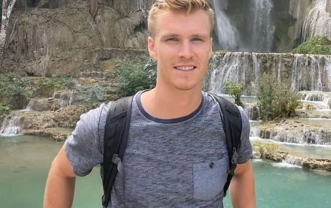 Man in front of a waterfall.