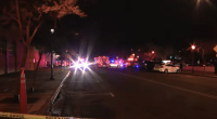 Nighttime street scene with emergency vehicles and police tape.