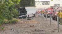 Tour bus crash scene with emergency responders.