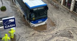 Bus submerged in floodwaters.