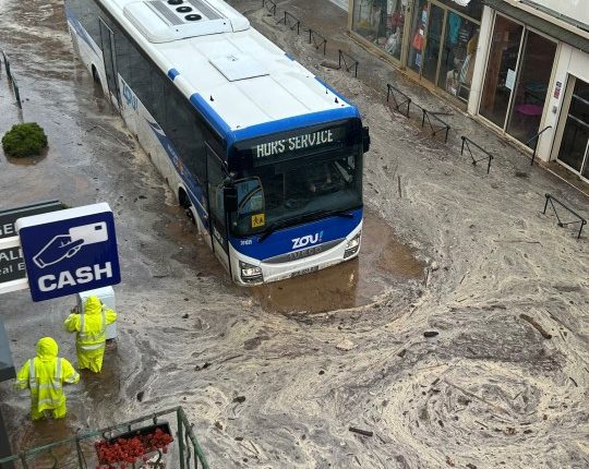 Bus submerged in floodwaters.