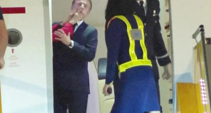 Emmanuel Macron being slapped by a woman as he exits a plane.