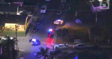 Aerial view of a crime scene with police cars at night.