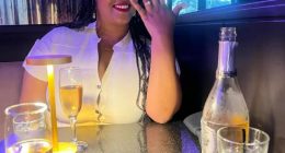 Woman showing off engagement ring at restaurant.