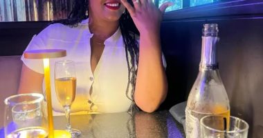 Woman showing off engagement ring at restaurant.