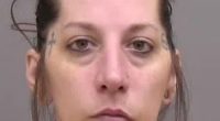 Mugshot of a woman with tattoos.
