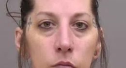 Mugshot of a woman with tattoos.
