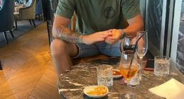 Man sitting at a table with drinks and snacks.