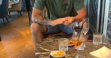Man sitting at a table with drinks and snacks.