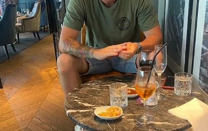 Man sitting at a table with drinks and snacks.