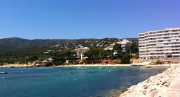 Portals Nous, Majorca: a beach with turquoise water, boats, and buildings on a hillside.