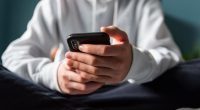 Close-up of a teen's hands holding a smartphone.