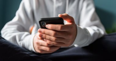 Close-up of a teen's hands holding a smartphone.