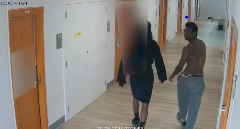 CCTV footage of two people walking down a prison corridor.