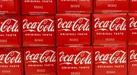 Close-up photo of multiple Coca-Cola 12-packs on a store shelf.