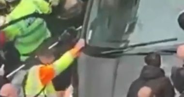 Police officers removing a driver from a car during a Liverpool parade.
