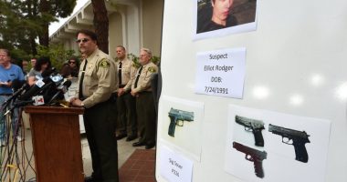 Photo of a press conference where law enforcement officials display photos of Elliot Rodger and the weapons used in the Isla Vista shooting.