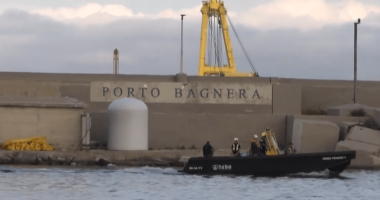 Small boat near Porto Bagnera harbor wall.