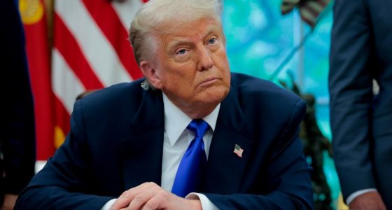 President Trump seated at a desk in the Oval Office.