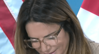 Woman with glasses at a press conference.