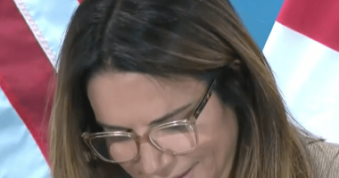 Woman with glasses at a press conference.