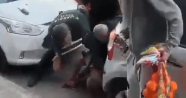 People assisting a person on the ground.
