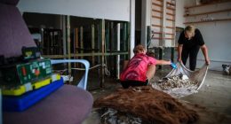 TAREE, AUSTRALIA - MAY 23: Business owners clean their shop following a flood at Albert street on May 23, 2025 in Taree, Australia. Catastrophic flooding struck the Mid North Coast and other parts of New South Wales, isolating over 50,000 residents, prompting hundreds of rescues, and leaving at least one person dead and several missing as emergency services responded to record-breaking rainfall. (Photo by Roni Bintang/Getty Images)