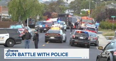 Police cars and emergency vehicles at the scene of a gun battle.