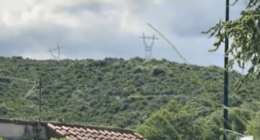 High-voltage power lines on a hillside.