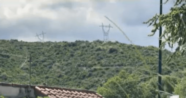 High-voltage power lines on a hillside.