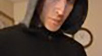 Close-up of a person wearing a dark hooded sweatshirt.
