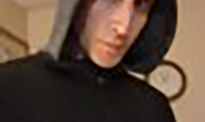 Close-up of a person wearing a dark hooded sweatshirt.