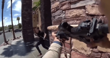 Person aiming a rifle at another person running away.