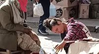 A young woman assisting a homeless man.