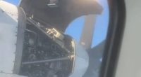 Airplane engine cover open mid-flight.